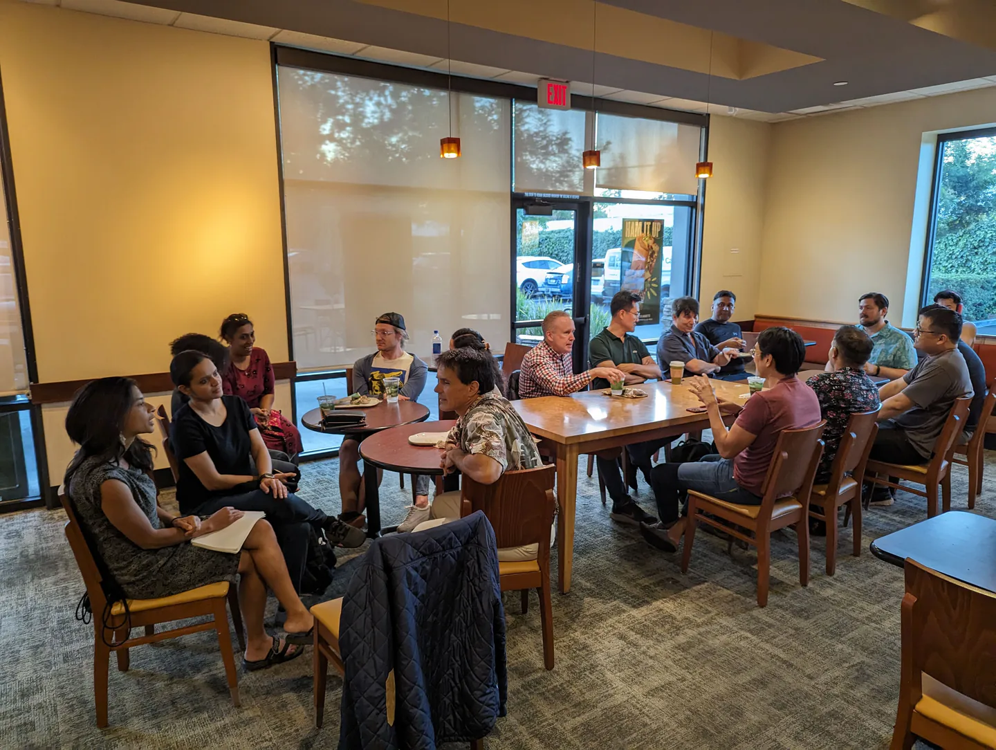 Small groups talking across several tables at Panera Bread in Sunnyvale.