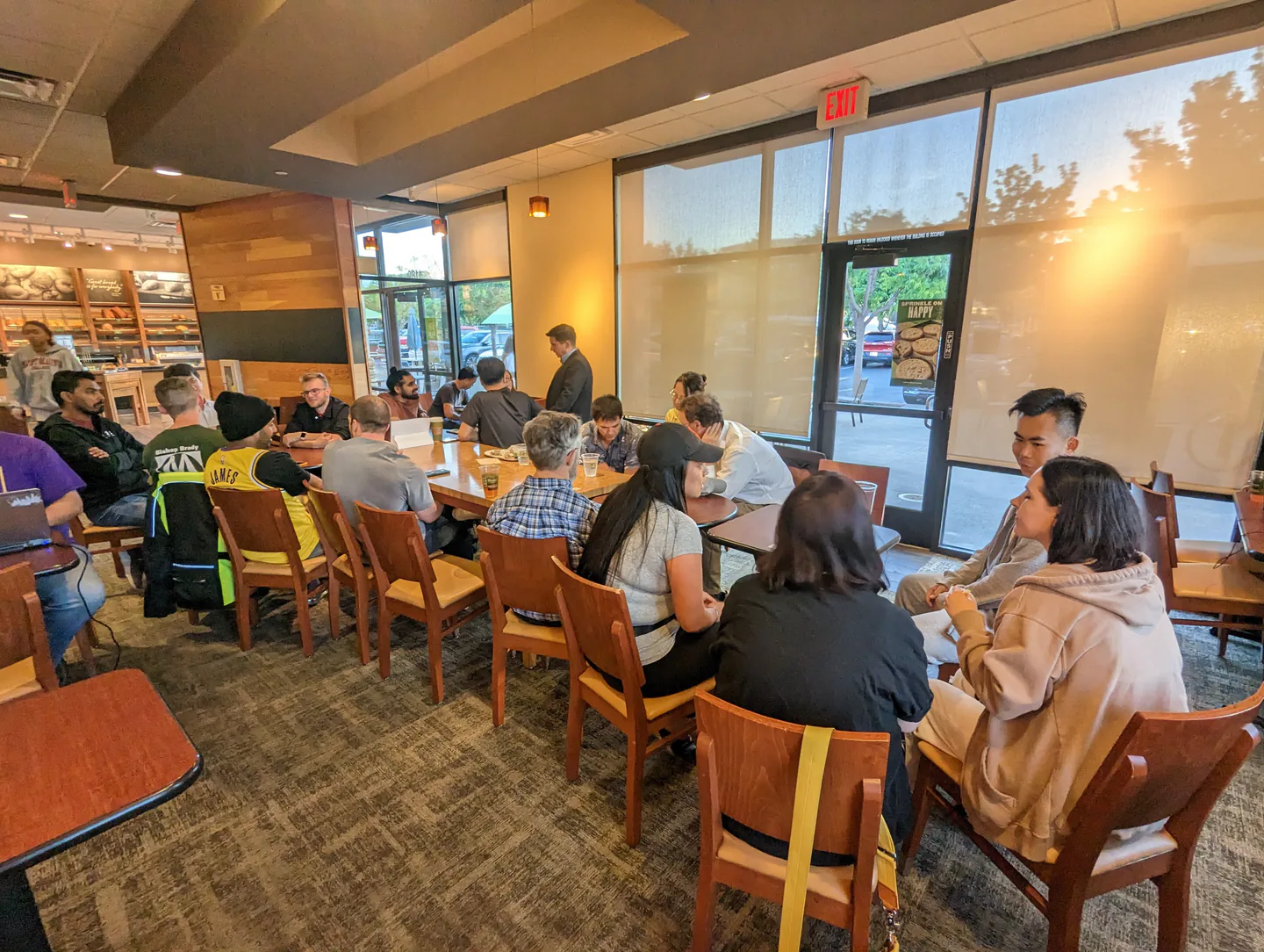 People talking around several tables at a Sunnyvale café meetup.