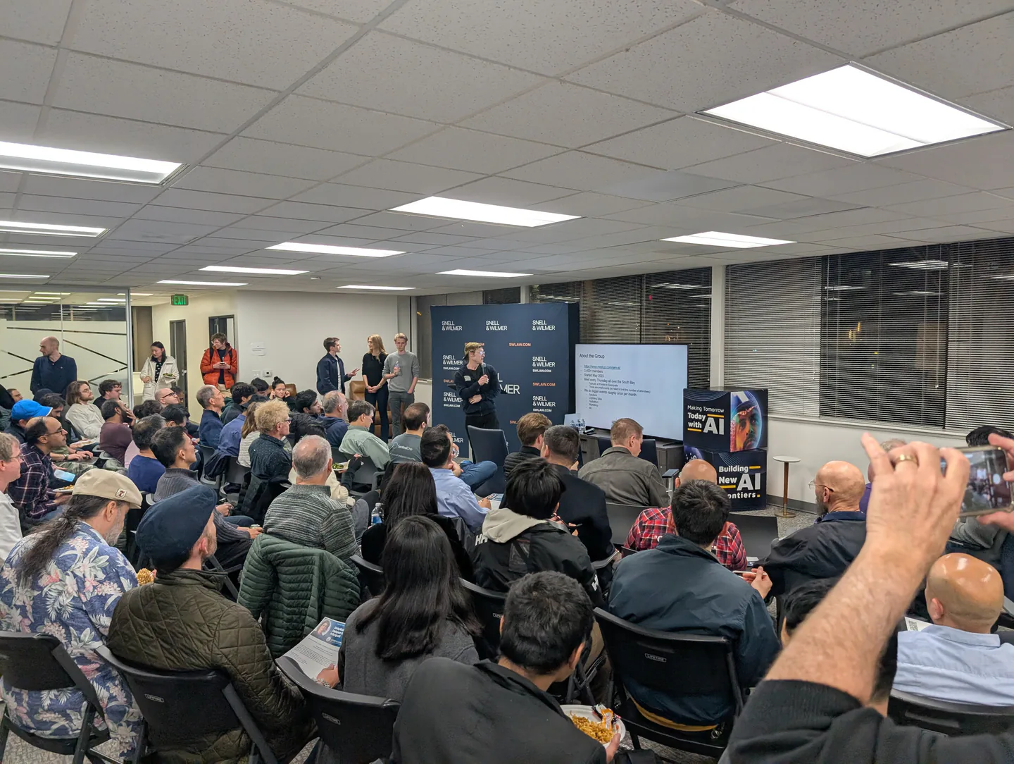 A crowded room listening to a presentation at our Sentient Foundation event.